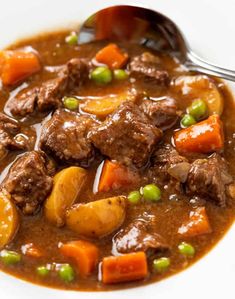 a white bowl filled with beef stew and carrots