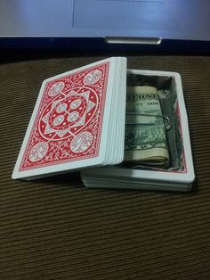 two playing cards with money in them sitting on a table