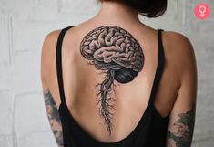 the back of a woman's neck with a brain and roots tattoo on it