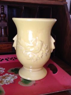 a yellow vase sitting on top of a red tray