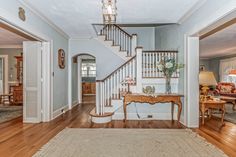 an entry way with stairs and a table in the middle