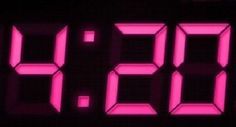 a digital clock with the time 11 00 is shown in pink light on a black background