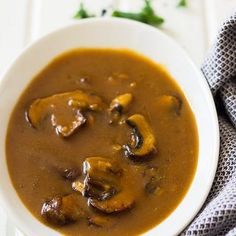 a white bowl filled with mushroom soup on top of a table