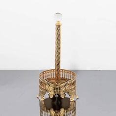 a golden candle holder with an ornate design on it's base and a crystal ball in the middle