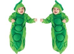 two babies dressed in peas costumes, one holding hands and the other looking at each other