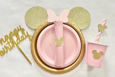 a pink and gold mickey mouse birthday party set up with paper plates, napkins, straws and cups