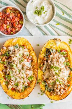 two stuffed squash halves with meat and veggies in the middle on a serving tray