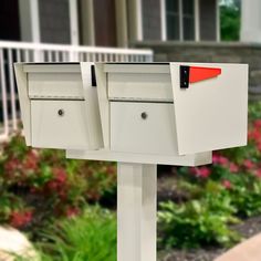 two white mailboxes in front of a house