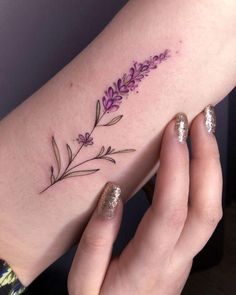 a woman's arm with purple flowers and leaves on the left side of her body