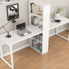 a computer desk with a laptop on top of it next to a bookshelf