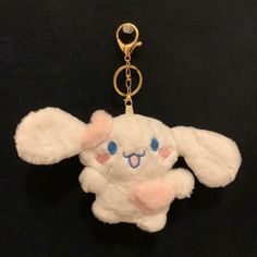 a keychain with a stuffed animal hanging from it's side on a black surface