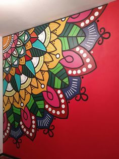 a large colorful painting on the side of a red wall in an office space with wood floors