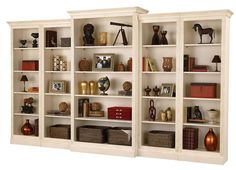 two white bookshelves filled with different types of items