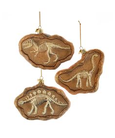 three dinosaur ornaments hanging from hooks on a white background