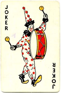 the joker playing card has red dots on it and is holding a drum in one hand