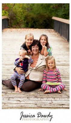 a woman and two children are sitting on a bridge