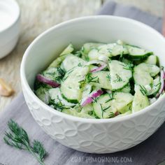 a white bowl filled with cucumbers and onions