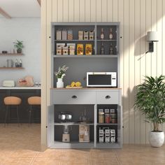 a microwave oven sitting on top of a gray cabinet next to a potted plant