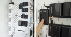 a hand is pressing the button on a wall mounted power strip that has several batteries attached to it