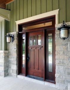 the front door to a house with two lights on each side and an entry way