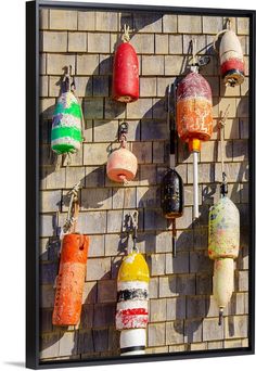 there are many buoys hanging up on the brick wall and in front of it