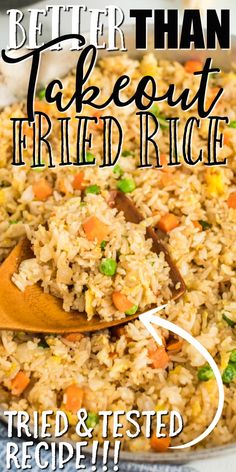 a close up of rice and carrots in a pan with a wooden spoon next to it