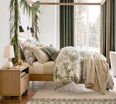 a bedroom with a canopy bed and green drapes on the windowsill, along with a white rug