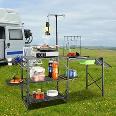 a camper trailer with food and drinks on the grass