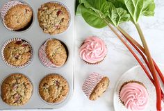 muffins with pink frosting and spinach leaves next to them