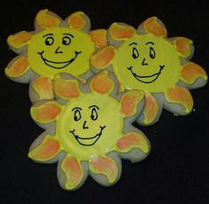 three sun cookies with faces drawn on them are sitting next to each other in front of a black background