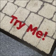 a door mat with the word tv me painted on it in red and grey squares