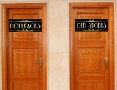 two wooden doors with old sports signs on the front and back sides, both showing names