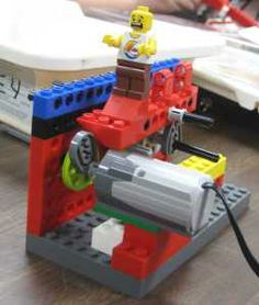 a lego man is sitting on top of a small toy car that's attached to a laptop