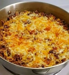 a large skillet filled with cheese and meat on top of a stove burner