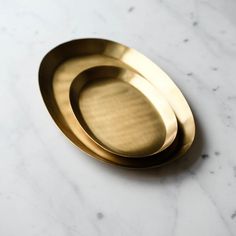 two brass plates sitting on top of a white counter