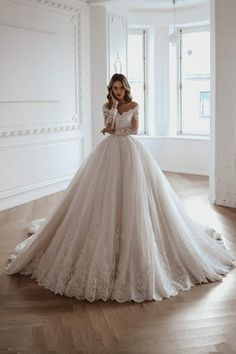 a woman in a wedding dress standing on the floor