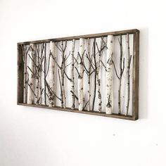 a wall mounted art piece with birch trees in the middle and branches on each side