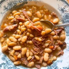 a bowl filled with beans and ham on top of a blue and white table cloth