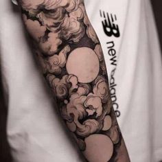 a man with a cloud tattoo on his arm is shown in black and grey colors