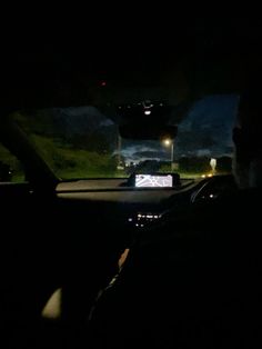 the interior of a car at night, with headlights on and dark lighting from inside