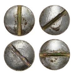 four metal buttons with some rust on them and one has a piece of wood sticking out of it