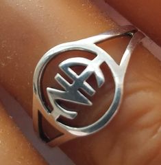 a close up of a person's hand wearing a ring with the letter w on it