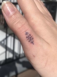 a woman's hand with a small tattoo on it