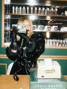 a woman taking a selfie in front of a desk with an old typewriter