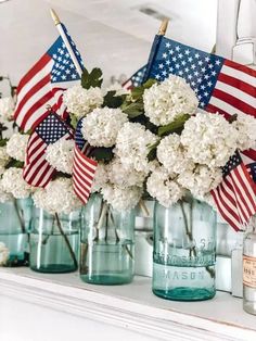 patriotic flowers are in mason jars with american flags on the top and one is filled with hydrangeas