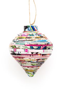 an ornament made out of magazines hanging from a string on a white background