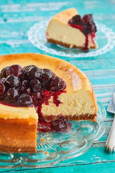 a slice of cheesecake with cherries is on a glass plate next to the rest of the cake