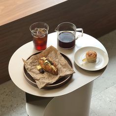 there is a plate with food on it next to a cup of tea and a muffin