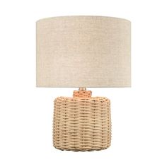 a wicker table lamp with a beige shade