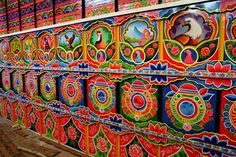 colorfully painted wall with lots of different designs on it's sides and windows